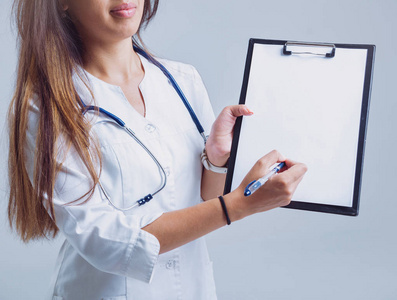 年轻护士或医生在眼镜与听诊器反对白色墙壁
