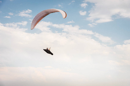 孤独的滑翔伞在蓝天的云层背景下飞翔。阳光明媚的一天, 天空中的滑翔伞