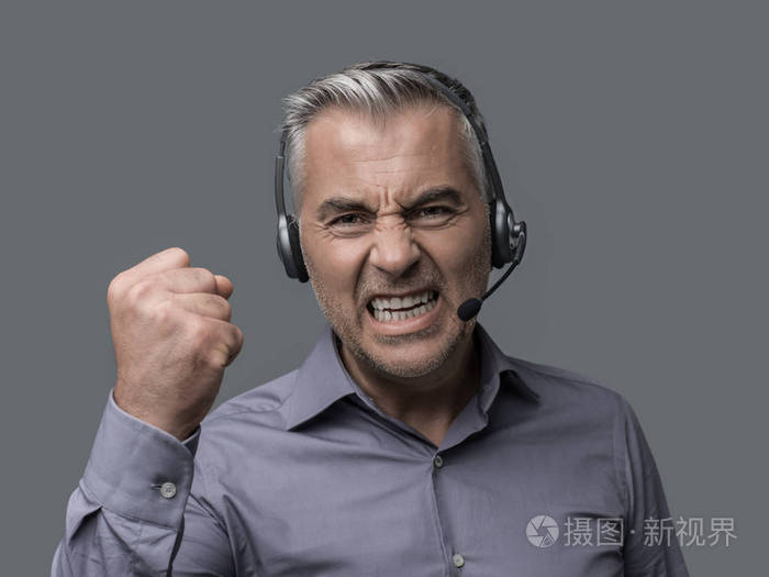 愤怒的积极的客户支持电话运营商与耳机, 他是大喊大叫, 并与客户进行