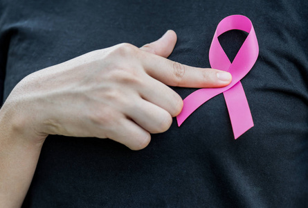 妇女手持有粉红色丝带支持乳腺癌意识月运动