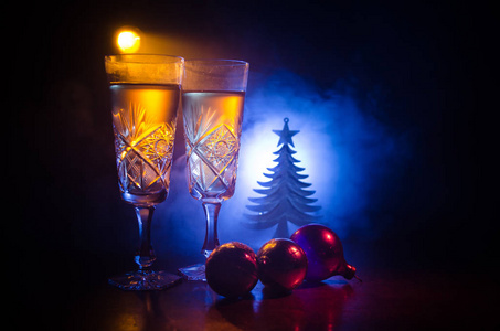 新年前夕庆祝背景与长笛和瓶香槟与圣诞属性 或元素 在白雪皑皑的黑暗色调雾背景。选择性焦点。作为贺卡有用