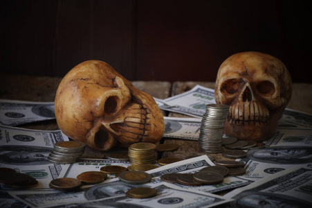 上的头骨和硬币, 金钱, 概念在工作为金钱和死亡由于金钱