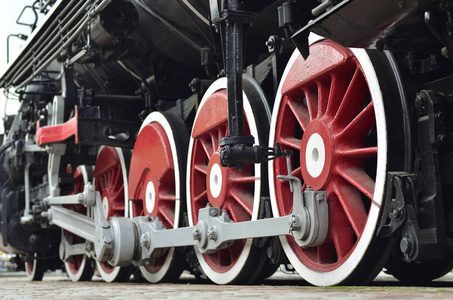 老苏联黑蒸汽机车的红色轮子。旧苏联蒸汽火车车轮