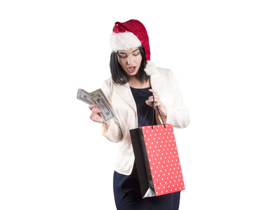 美丽的女孩帽圣诞老人黑发购物包孤立, 一捆钱, 美元