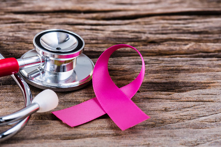 粉红色丝带和听诊器的木背景支持乳腺癌意识月活动