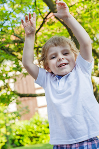 微笑着快乐的小男孩在花园中的肖像