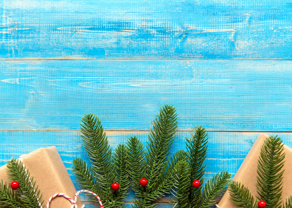 圣诞礼物盒和圣诞树的圣诞冬天在蓝色的木制背景。具有复制空间的顶部视图