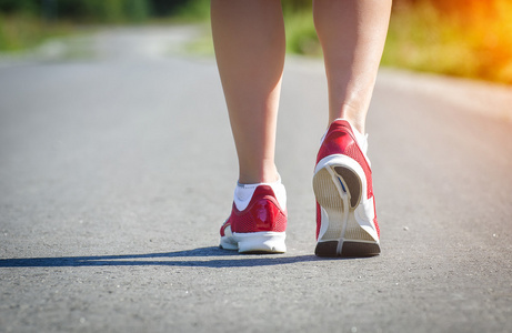 在日落时的户外体育锻炼期间的女性双腿。概念