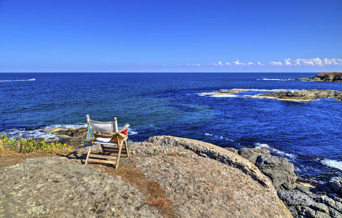美丽的风景与木椅子在岩石海岸