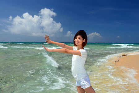年轻女子在沙滩上的享受阳光