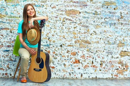 微笑的年轻女子坐在一起的吉他