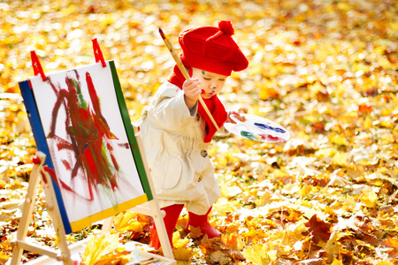 儿童风景画秋天在秋天的公园在画架上画画的孩子.创意儿童发展照片