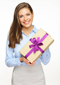 微笑的年轻女实业家在蓝色衬衣藏品礼物箱子用紫弓
