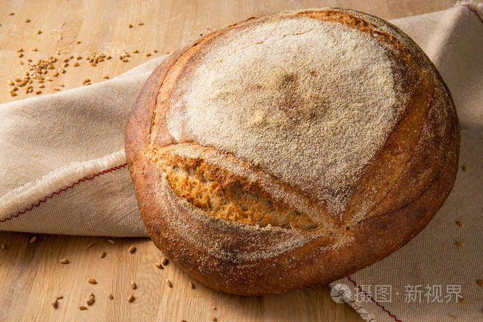 圆面包与结壳在麻布背景以麦子五谷