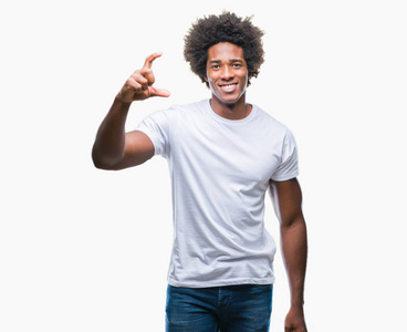 非裔美国男子在孤立的背景下微笑和自信的手势与手做尺寸标志, 而在看和相机。度量概念
