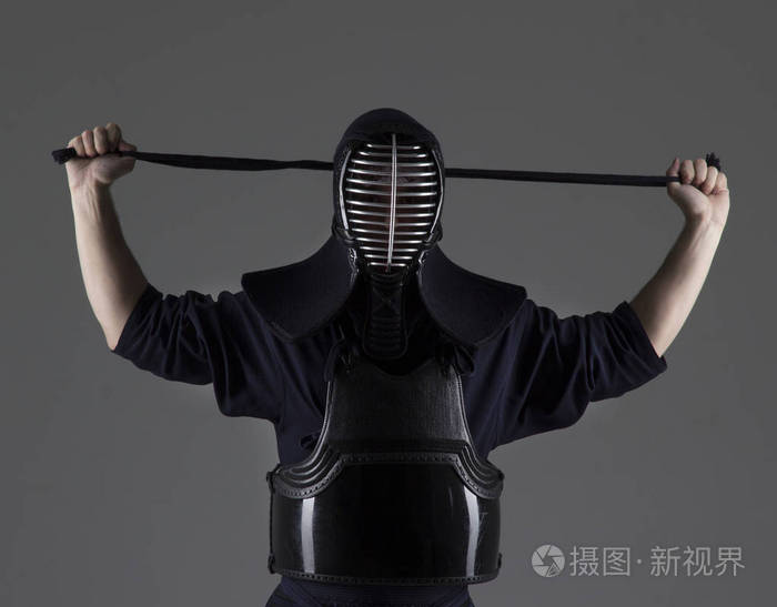 男性在传统剑道护甲把自己的头盔和准备战斗的肖像