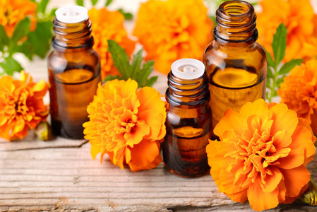 万寿菊精油和花在木桌上照片