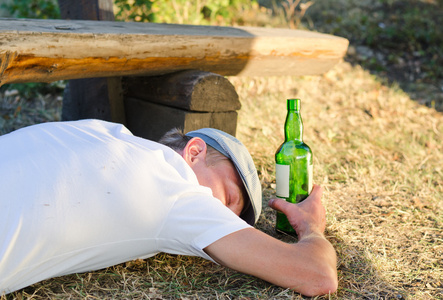 醉酒的男子在夏天睡在地上照片
