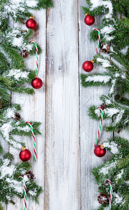 白雪皑皑的圣诞红色饰物和糖果手杖的垂直边界