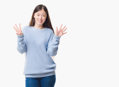 年轻的中国妇女在孤立的背景下显示和指向手指数八, 而微笑着自信和