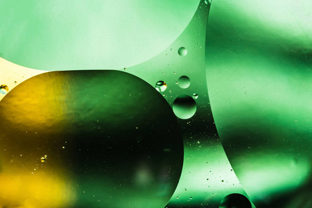 水和油, 美丽的颜色抽象背景基于绿色和黄色的圆圈和椭圆形, 宏观抽象