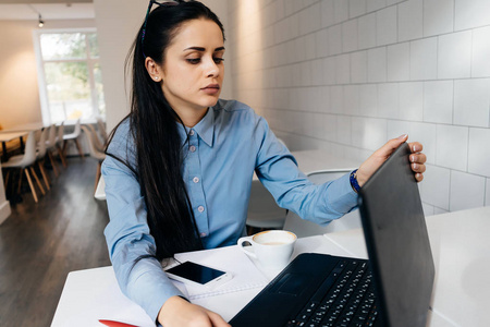 努力女孩疲惫的年轻女孩自由职业者工作努力, 与笔记本电脑坐在咖啡馆