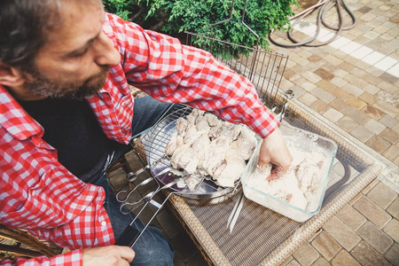 双手放在烤肉架上的肉块