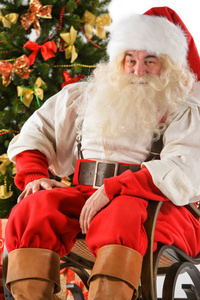 圣诞老人坐在摇椅上附近的圣诞树