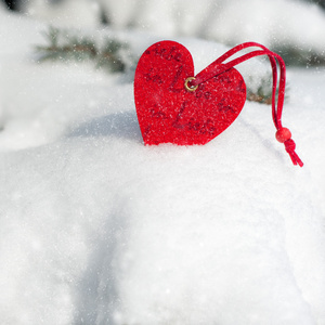 红色的心玩具在杉木树上降雪