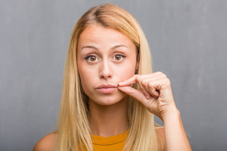 自然年轻的金发女子的肖像保持秘密或要求沉默