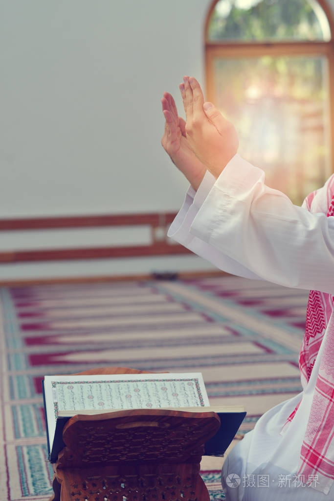 回教人民的手祈祷与清真寺内部背景