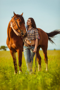 美丽的女人站在一匹马