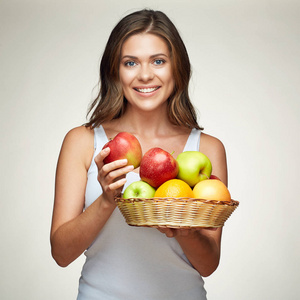 微笑的女人拿着水果设置。红色 绿色的苹果。橘子