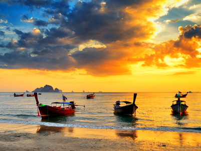 日落海滩的传统泰式船
