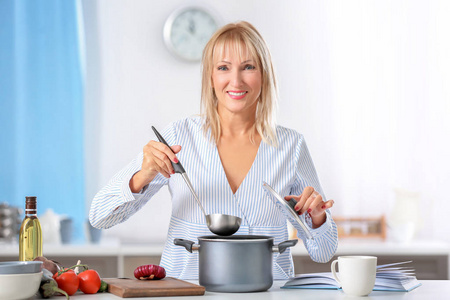 美丽成熟的女人在厨房做饭图片