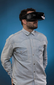 戴着虚拟现实护目镜的男人演播室射击, 蓝色 backgrou