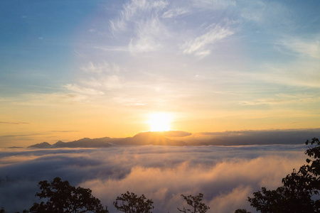 山范围与可见的剪影通过早晨五颜六色的雾。山谷笼罩着雾, 有一个美丽的日出