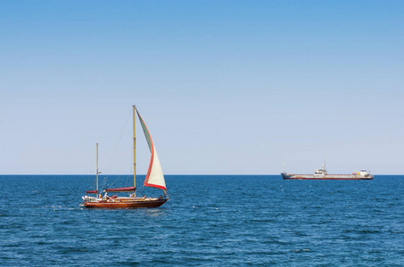 乘船旅行在游艇在开阔的大海。游艇与游客和货船在黑海