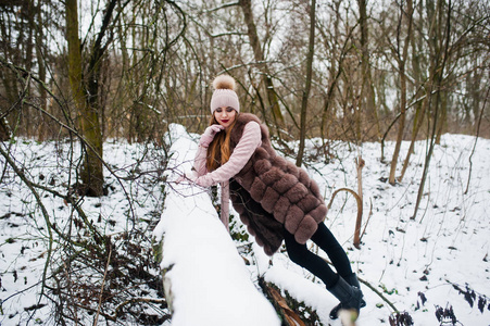 在冬季森林的毛皮大衣和头饰时尚女孩