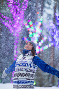 快乐的寒假妇女在公园雪圣诞灯