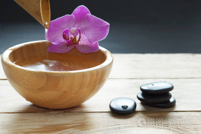 碗 从竹 兰花花和石头为热按摩透明水倾泻在一张小木桌照片 正版商用图片06j1tc 摄图新视界