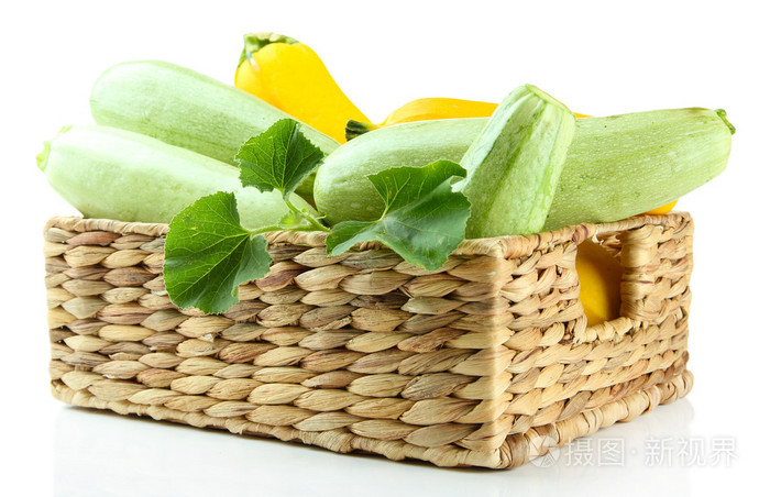 原料黄色和绿色西葫芦在柳条箱，隔离在白色