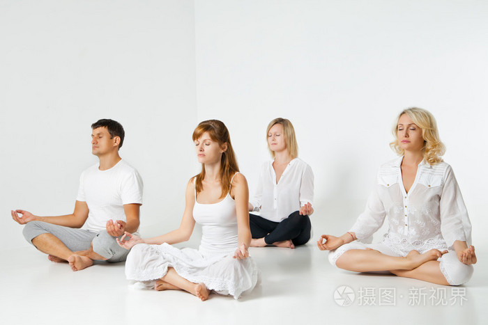 一群人放松和做瑜伽在白色