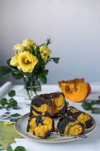 南瓜和巧克力蛋糕, 在一个质朴的褐色色板, 叶子作为装饰