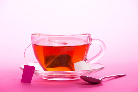 喝杯茶碟 茶匙 糖片在粉红色的背景上