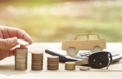 用汽车钥匙把钱放在一堆硬币上, 理财概念, 储蓄, 买卖车照片