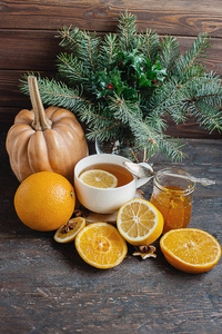 一杯热柠檬茶与橙色南瓜和姜果酱在木背景。健康饮料冷。冬饮