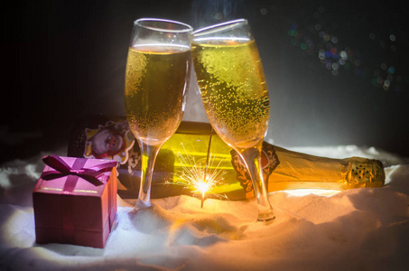 新年前夕庆祝背景与长笛和瓶香槟与圣诞属性 或元素 在白雪皑皑的黑暗色调雾背景。选择性焦点。作为贺卡有用