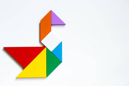 形状的天鹅白色背景的天鹅形状彩色木七巧板拼图照片