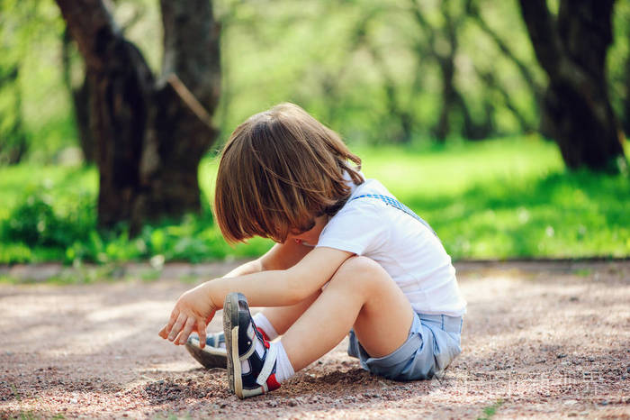 可爱的小男孩小孩玩泥巴, 坐在地上散步